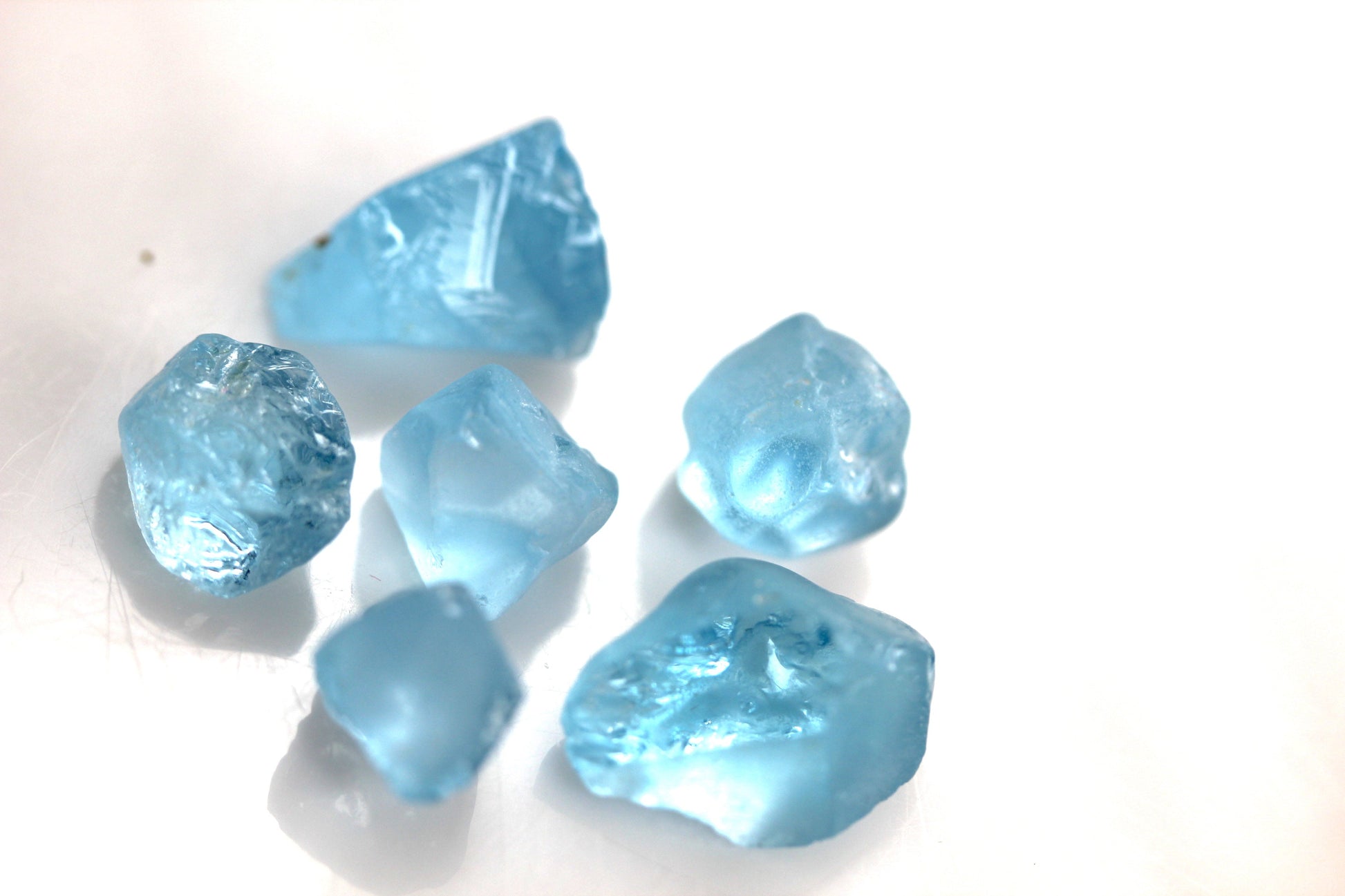 create blue topaz earrings after faceting this raw stone